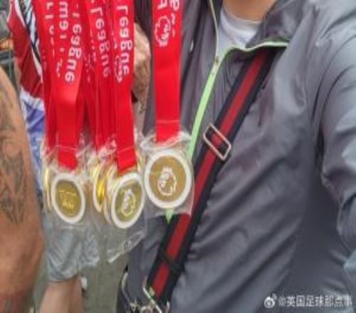 球迷在阿森纳冠军巡游卖奖牌，撕开贴纸写着：利物浦是冠军！